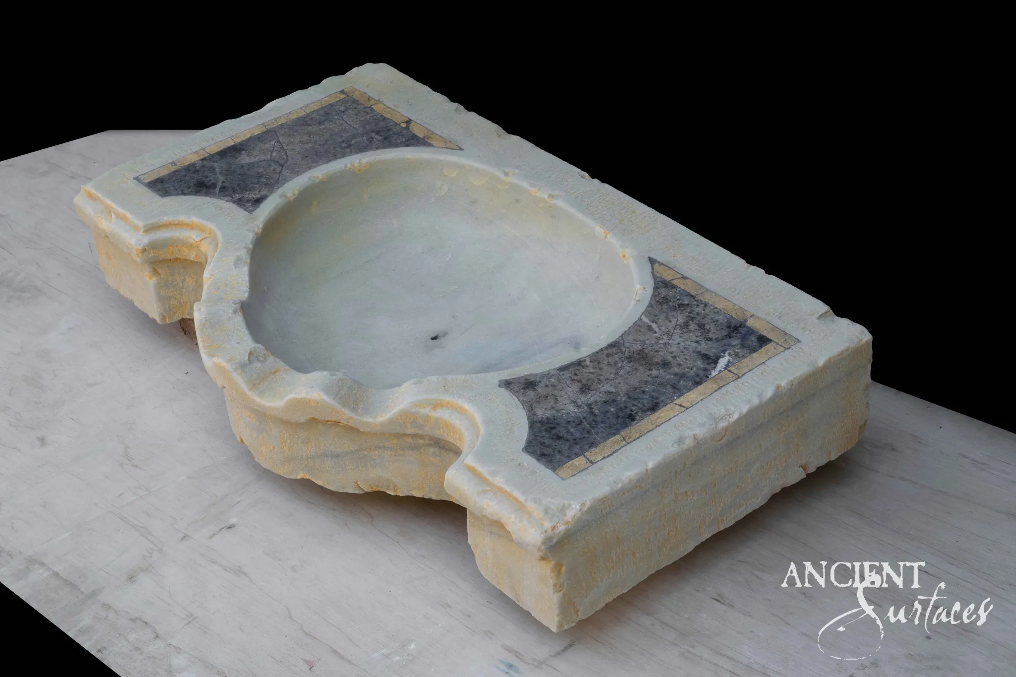 Thick limestone sink slab with a moulded serpentine front edge, large oval dished basin and two dark grey inlaid panels
