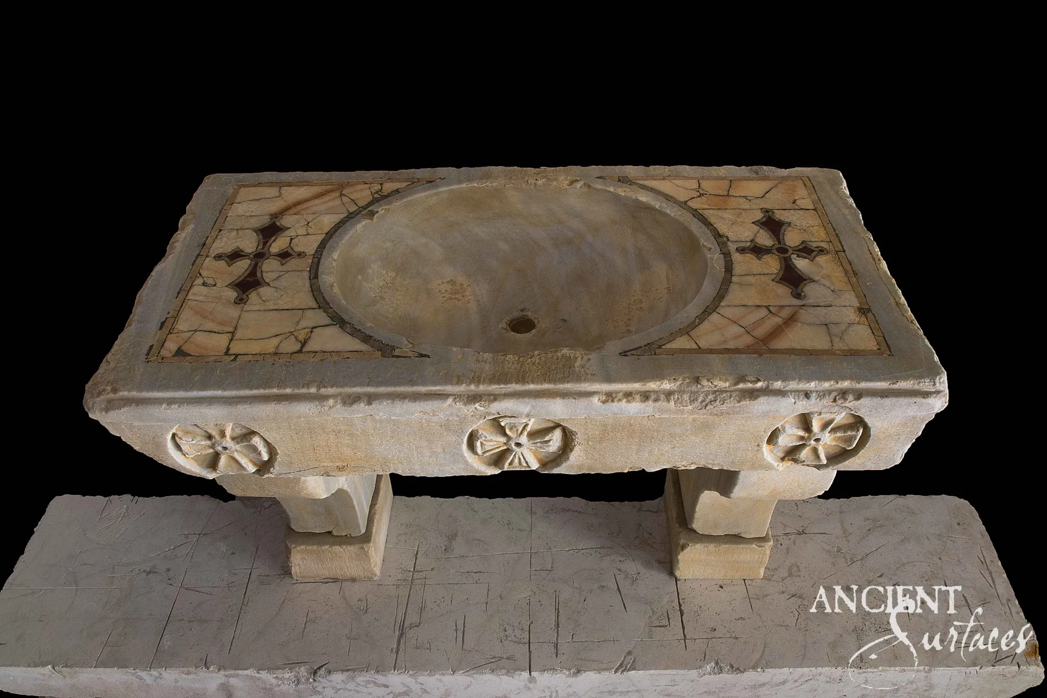 Pale limestone console sink with an oval basin, honey marble inlay carrying dark cross motifs and three carved rosettes on the apron