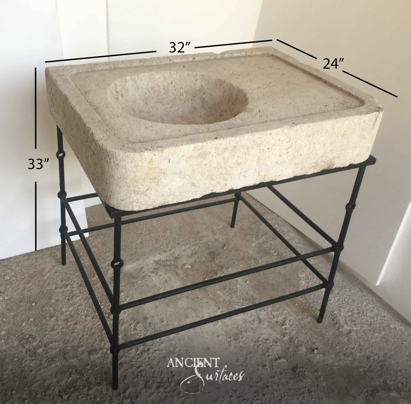 Pale pitted square limestone basin with a round scooped bowl and flat tap ledge resting on a slim wrought iron stand